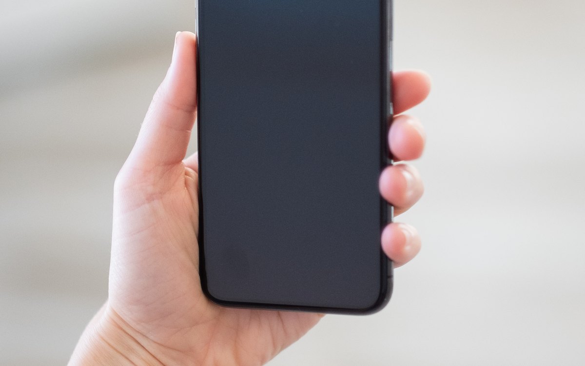 Phone held in one hand with a blank screen